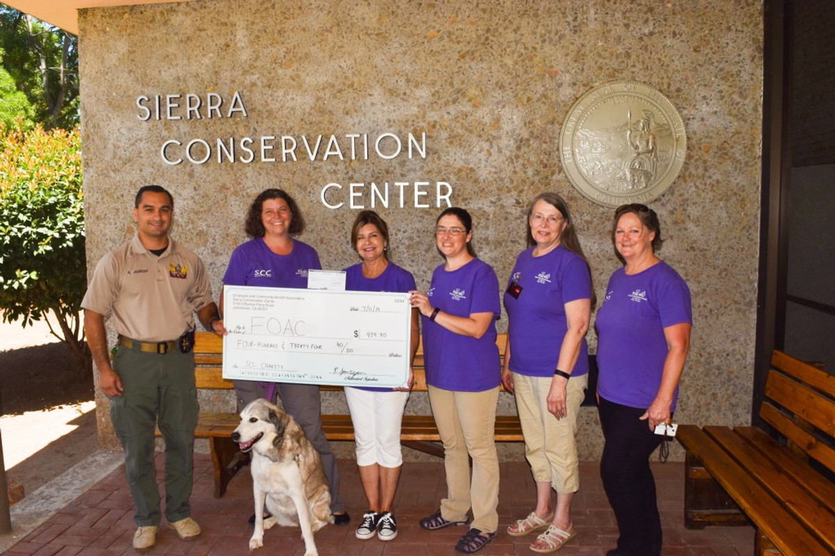 FOAC and Sierra Conservation Center representatives with a rescue dog and donation check